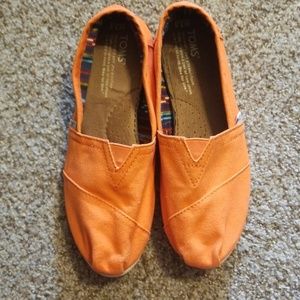 Orange TOMS slip on shoes